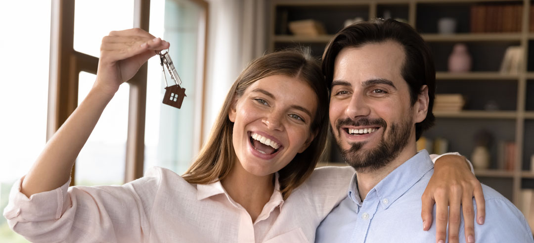 Pareja feliz con las llaves de su nueva casa