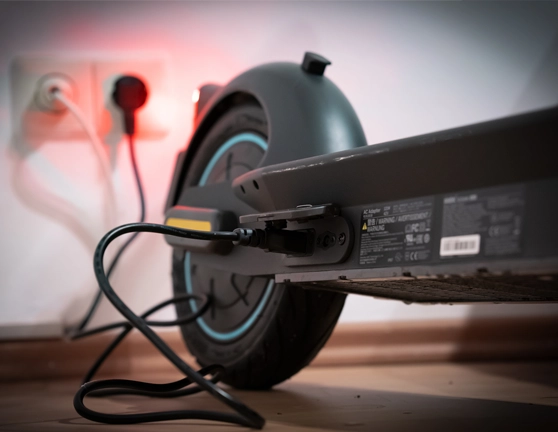 Patinete eléctrico cargando en un enchufe de casa