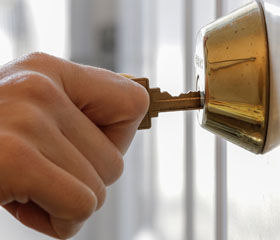 Persona abriendo la cerradura de una casa con la llave